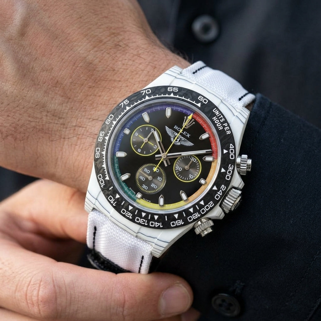 White forged carbon chronograph with a rainbow ring and a winged emblem on the wrist as a shirt cuff is fastened