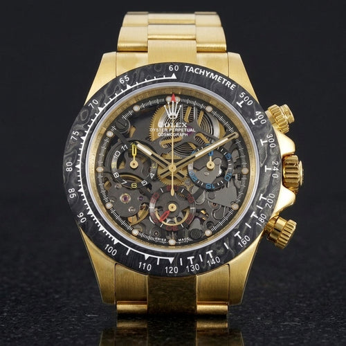 Yellow gold skeleton chronograph with a black marbled bezel, upright on polished black granite
