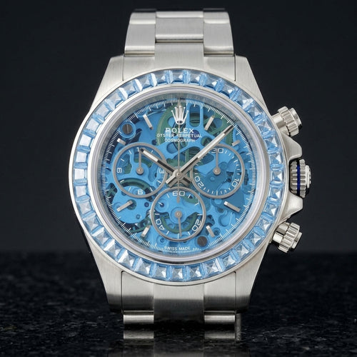 Steel skeleton chronograph with a sky-blue stone bezel and a sky-blue skeleton dial, upright on polished black granite