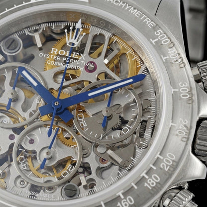 Macro of the grey skeleton dial with gold-toned wheels, open steel-ringed sub-dials and royal-blue hands