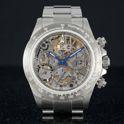 Steel skeleton chronograph on its three-row steel bracelet, worn on the wrist below a dark suit cuff