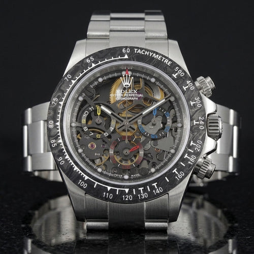 Steel skeleton chronograph with a marbled forged-carbon bezel and yellow, blue and red counters, upright on polished black granite