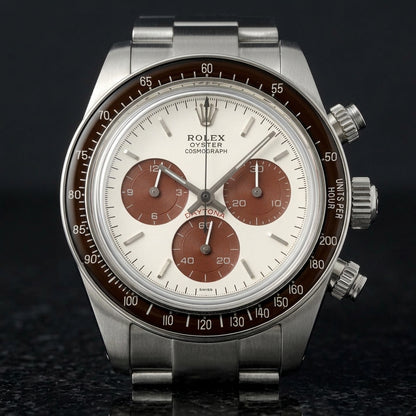 Steel chronograph with a white dial, brown counters and a brown bezel, upright on polished black granite
