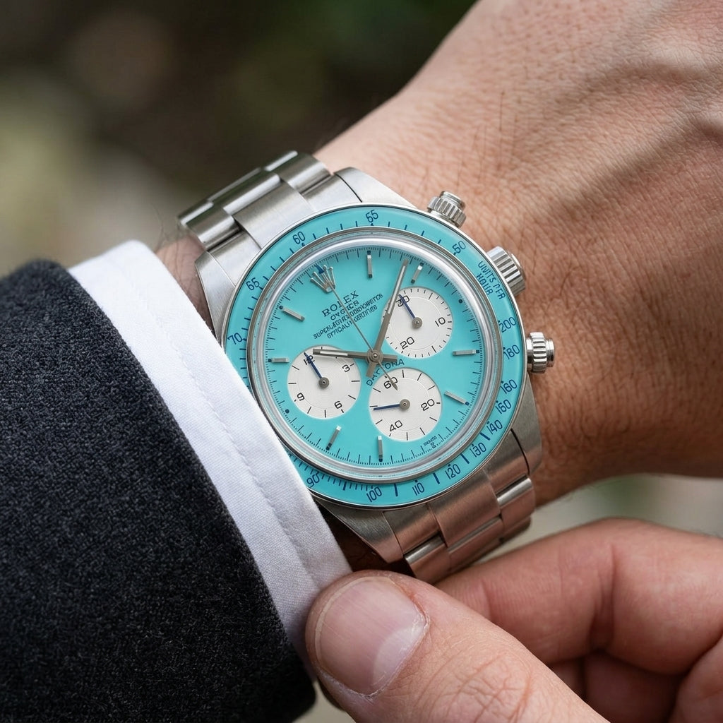 Steel chronograph with a turquoise dial on the wrist as a shirt cuff is fastened
