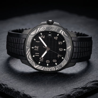 Forged-carbon watch at a three-quarter angle on dark slate, the swirled grey bezel beside the black fluted crown