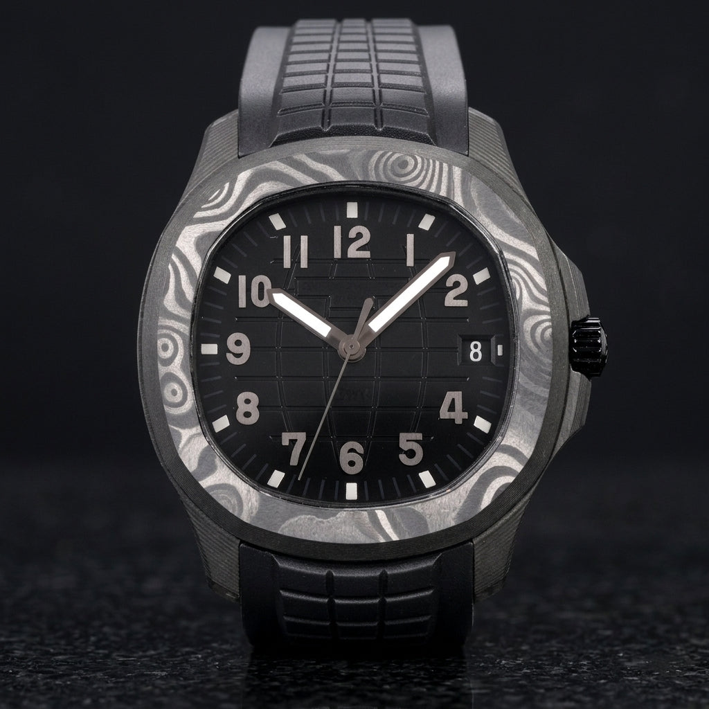 Forged-carbon watch with a black dial on its black rubber strap, worn on the wrist below a dark suit cuff