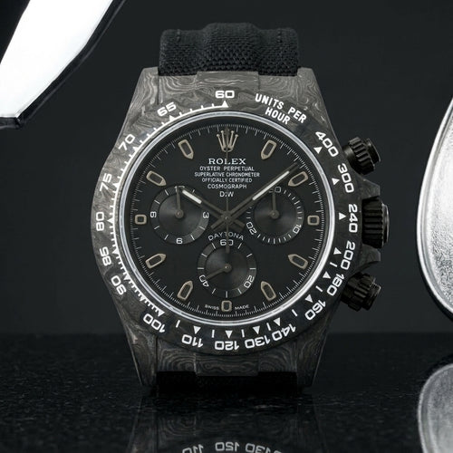 All-black forged-carbon chronograph with a matte black dial on dark stone