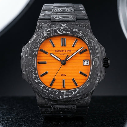 Orange-dial forged carbon sports watch on its black and silver-white carbon bracelet, worn on the wrist below a navy suit cuff