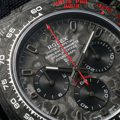 Macro of the carbon dial, its three turntable-brushed black counters and the red chronograph hand