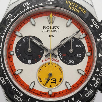 Macro of the cream dial inside the black marbled bezel, the red-orange minute ring and the yellow counter marked 73 at six