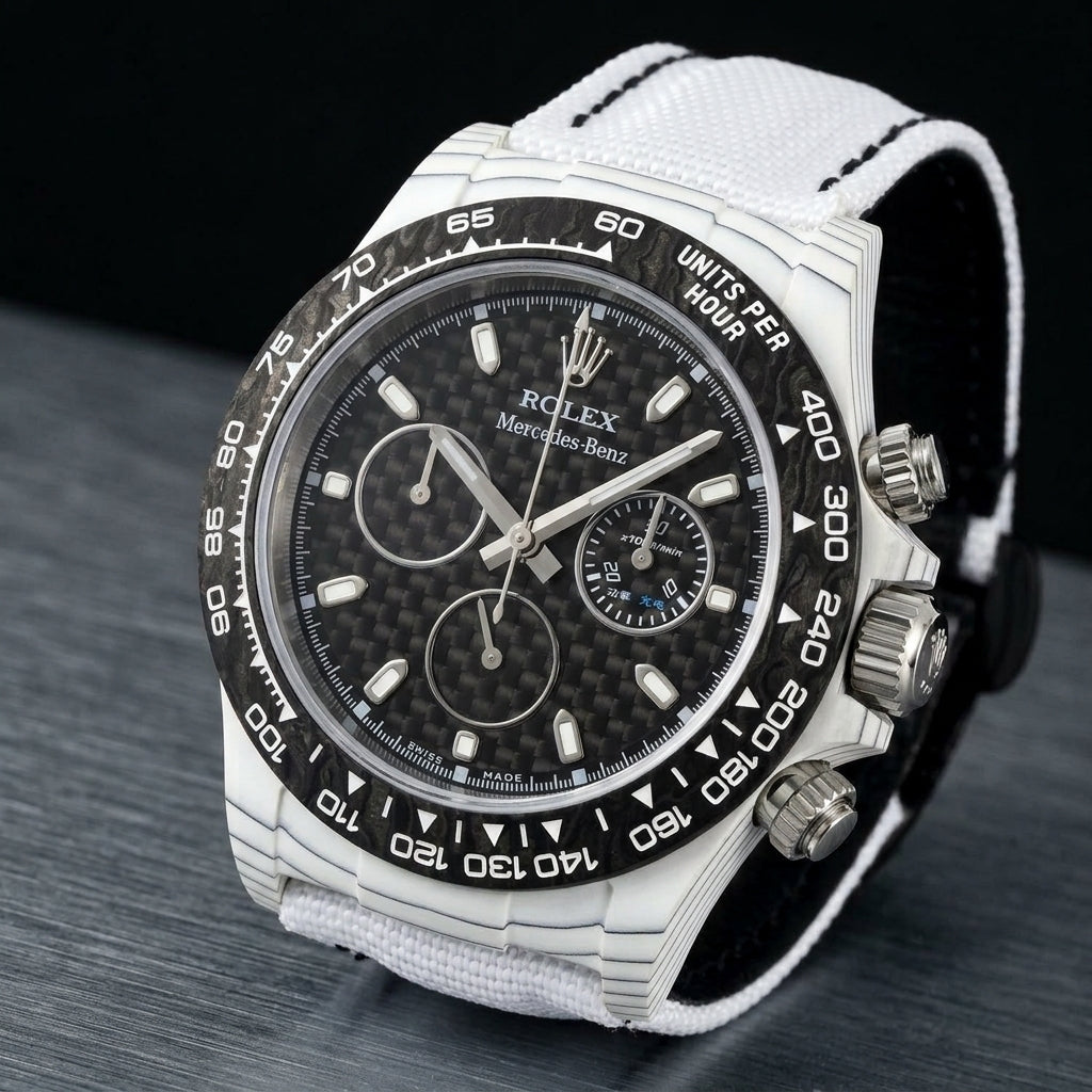 White forged carbon chronograph at a three-quarter angle on dark slate, fine dark layer lines along its flank