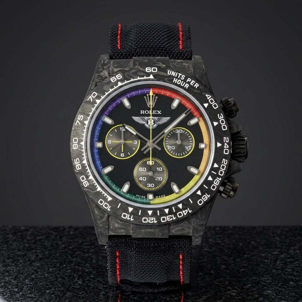 Black forged carbon chronograph with a glossy black dial ringed in rainbow colours, upright on polished black granite