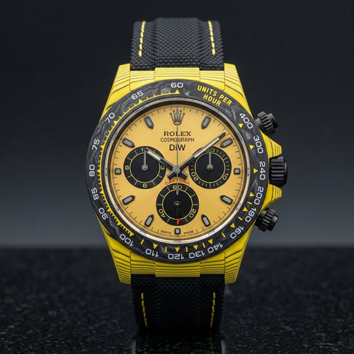 Yellow forged carbon chronograph with a black carbon bezel and a yellow dial with three black counters, upright on polished black granite