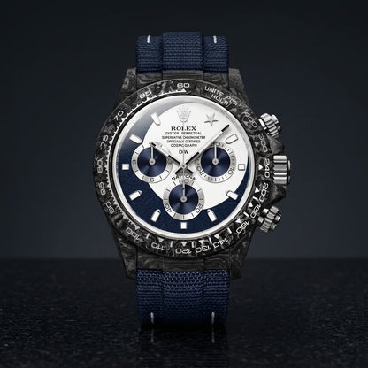 Forged-carbon chronograph with a white and navy dial and a star at twelve, on dark stone