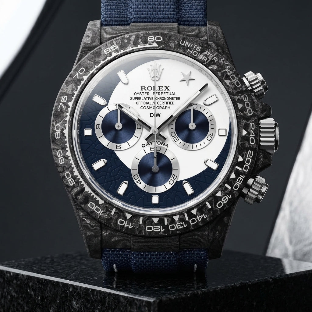 Forged-carbon chronograph on a navy woven strap, worn under a cuff