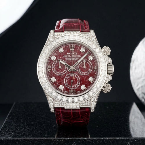 White gold chronograph with a red stone dial and baguette bezel on black granite