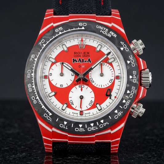 Red carbon chronograph with white pinstripes, a red-and-white dial and a black carbon bezel, upright on polished black granite