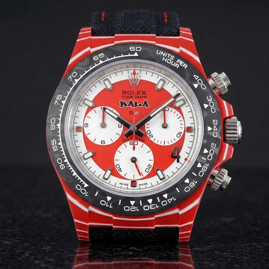 Red carbon chronograph with a red-and-white dial on its black canvas strap with red stitching, worn on the wrist below a dark suit cuff