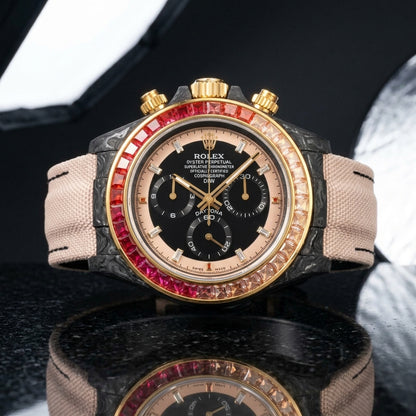 Forged carbon chronograph on a blush fabric strap worn under a suit cuff