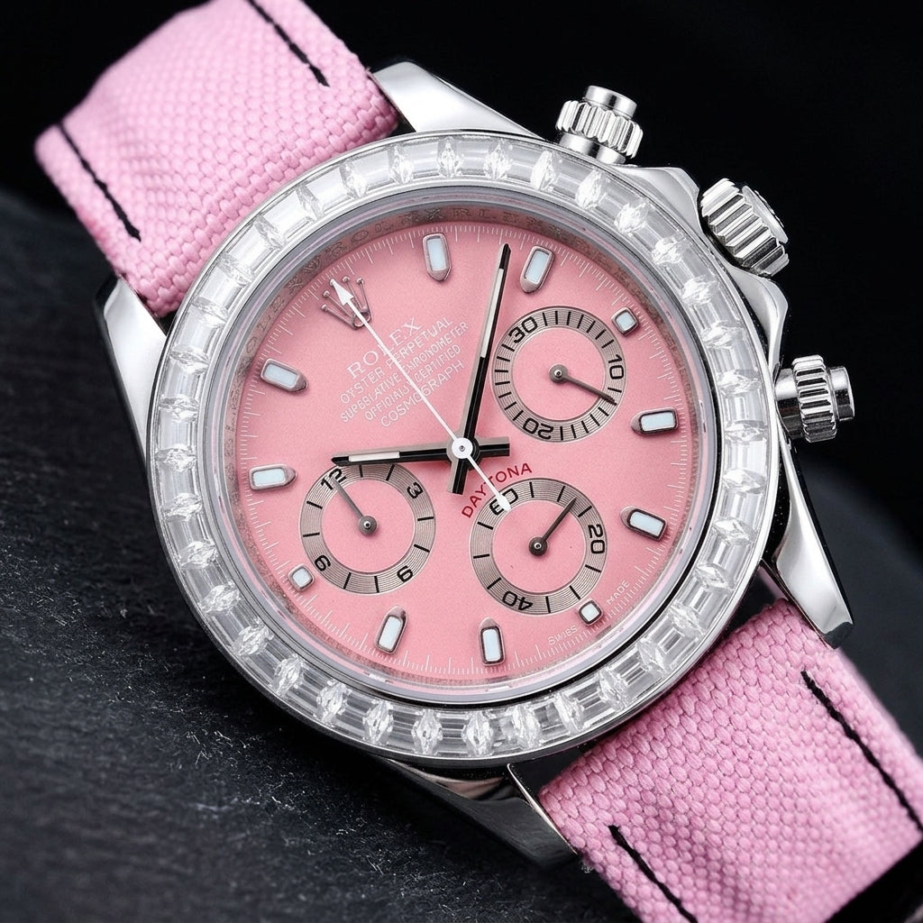 Steel chronograph at a three-quarter angle on dark slate, the clear stone bezel beside the steel crown and fluted pushers