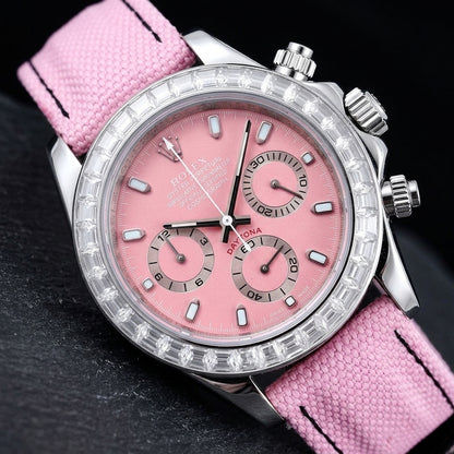 Steel chronograph at a three-quarter angle on dark slate, the clear stone bezel beside the steel crown and fluted pushers