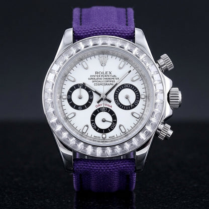Steel chronograph with a white dial, three black-ringed counters and a bezel of clear baguette-cut stones, upright on polished black granite