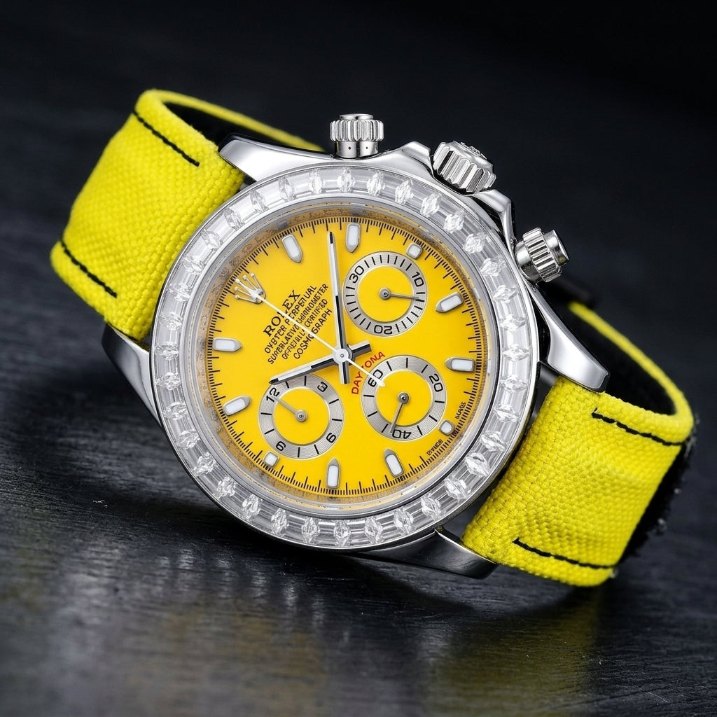 Steel chronograph at a three-quarter angle on dark slate, the clear stone bezel beside the fluted crown and screw-down pushers