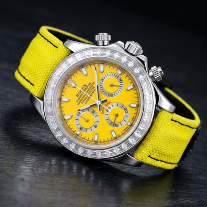 Steel chronograph at a three-quarter angle on dark slate, the clear stone bezel beside the fluted crown and screw-down pushers