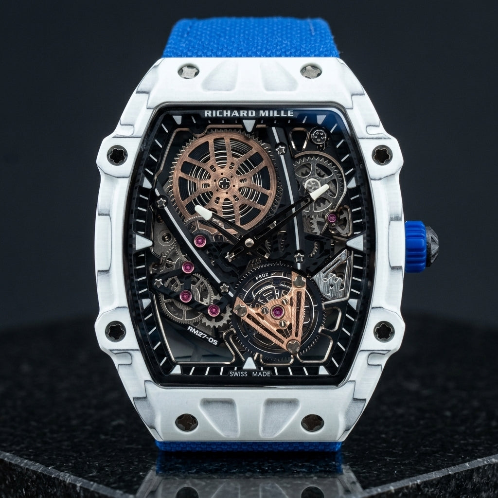 White tonneau skeleton watch with a flying tourbillon at six and a blue woven strap, upright on polished black granite