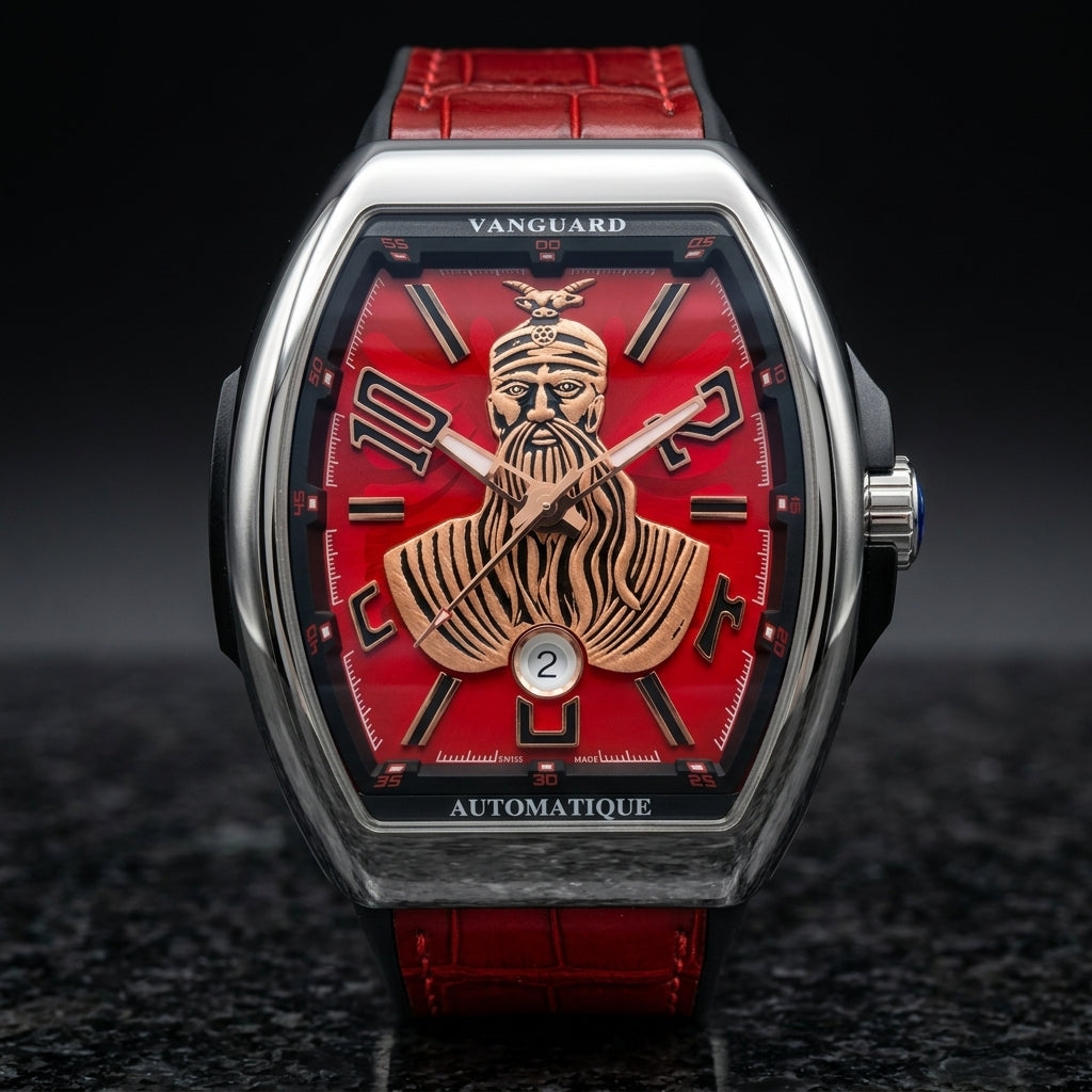 Steel curved tonneau watch with a red dial on its red strap, worn on the wrist below a dark suit cuff