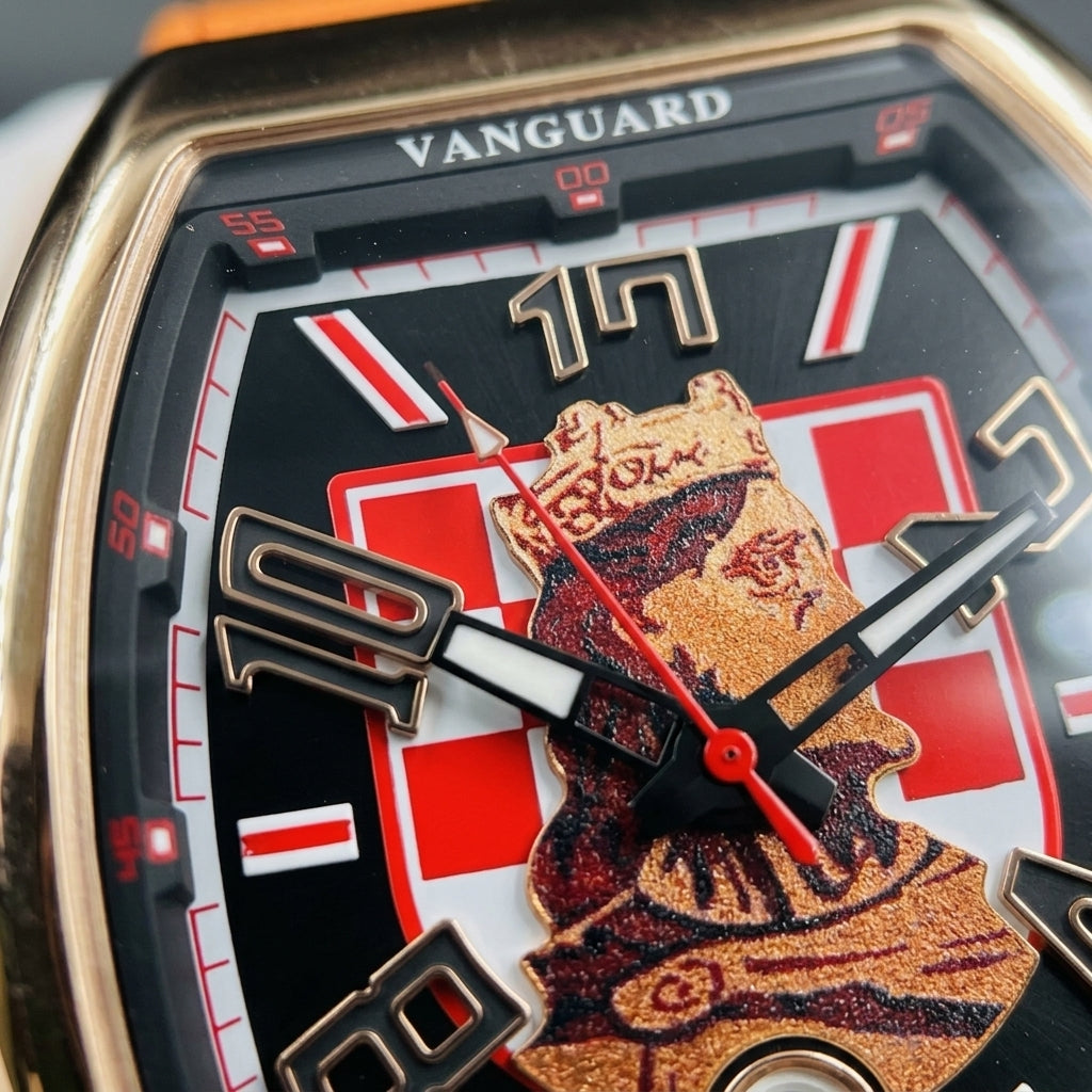 Macro of the black dial: the red-and-white checkerboard, the crowned king in copper-gold and the black numerals outlined in rose gold