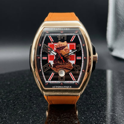 Rose gold curved tonneau watch with a checkerboard king dial on its orange strap, worn on the wrist below a dark suit cuff