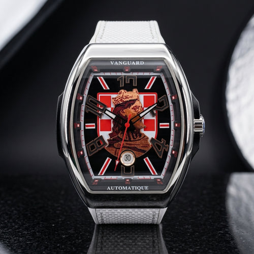 Steel curved tonneau watch with a black dial, a red-and-white checkerboard and a crowned king portrait, upright on polished black granite