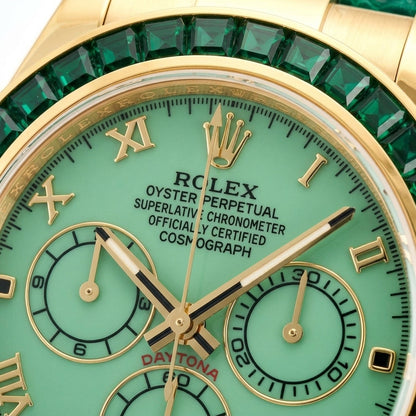 Macro of the pale green dial with gold Roman numerals, three pale green counters in gold rings and the green baguette stones at the edge