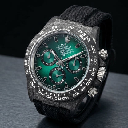 Forged-carbon chronograph at a three-quarter angle on dark slate, black strap