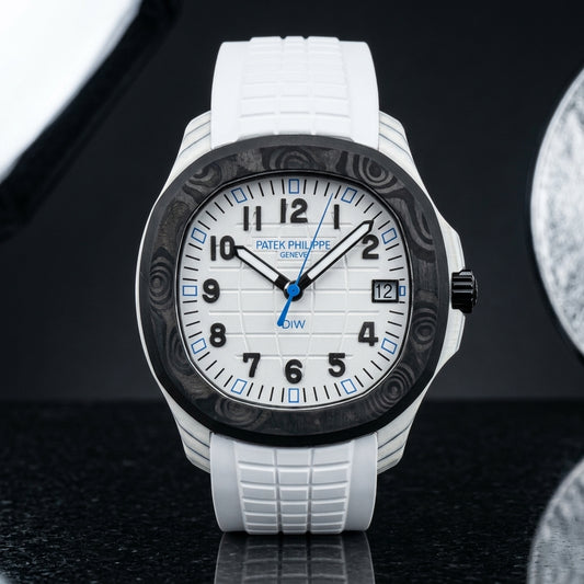 White carbon grid-dial watch with a black marbled bezel, black numerals and blue hour markers, upright on polished black granite