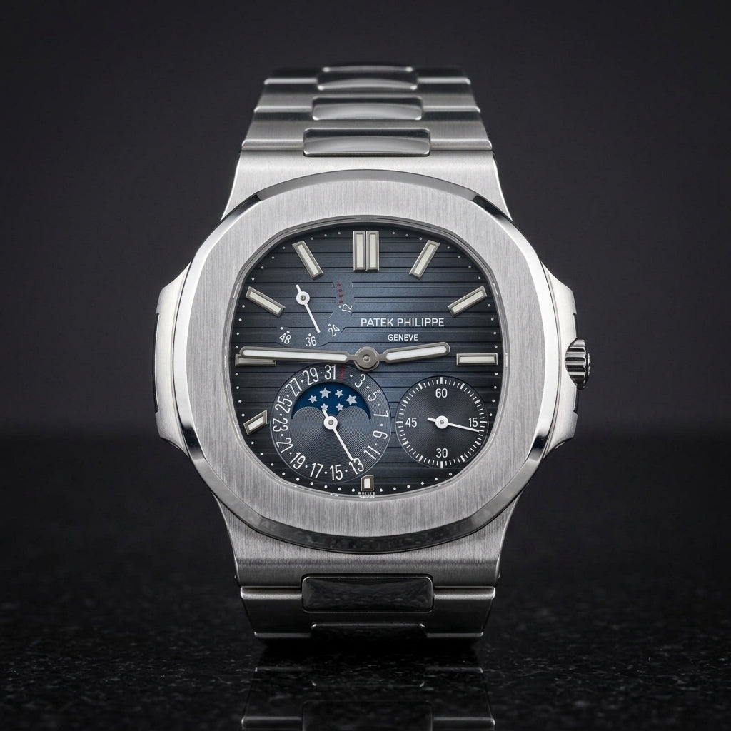Steel moonphase sports watch with a blue-to-black ribbed dial, upright on polished black granite