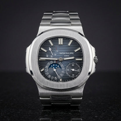 Steel moonphase sports watch with a blue-to-black ribbed dial, upright on polished black granite