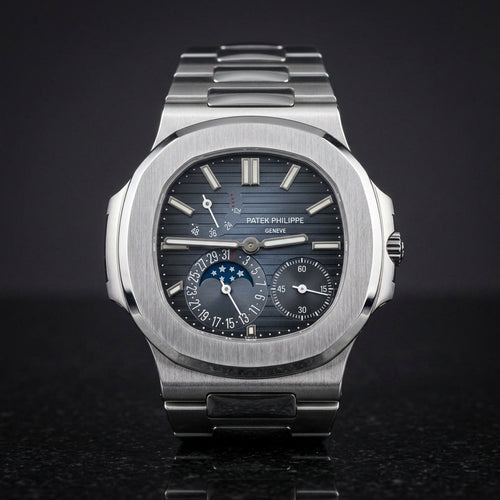 Steel moonphase sports watch with a blue-to-black ribbed dial, upright on polished black granite
