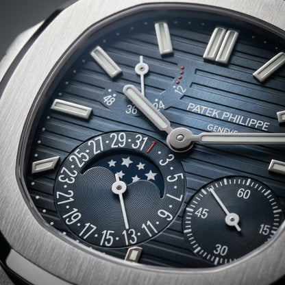 Macro of the blue gradient dial: the moon window with six stars, the date ring, the power-reserve gauge and the small seconds