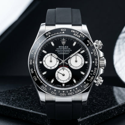Steel chronograph with a black ceramic bezel, black dial and three white counters, upright on polished black granite