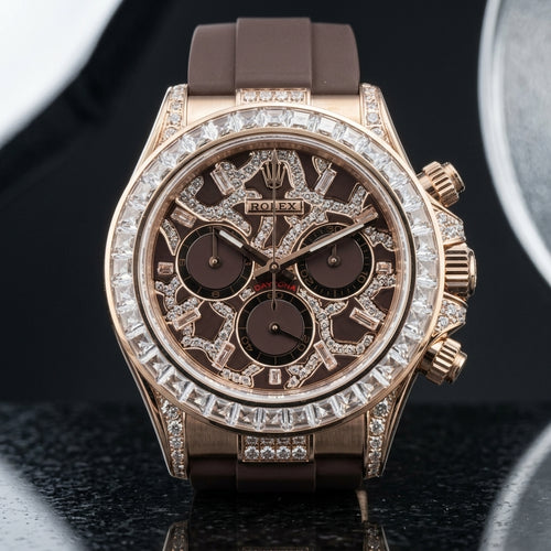 Rose gold chronograph with a brown leopard pavé dial and a clear baguette bezel, upright on polished dark marble