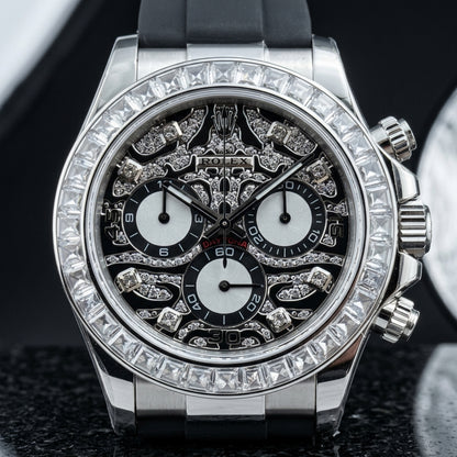 Steel chronograph with a black leopard pavé dial on a black rubber strap on the wrist below a dark suit cuff
