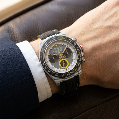 White CarboQuartz chronograph on a black woven strap, worn under a cuff