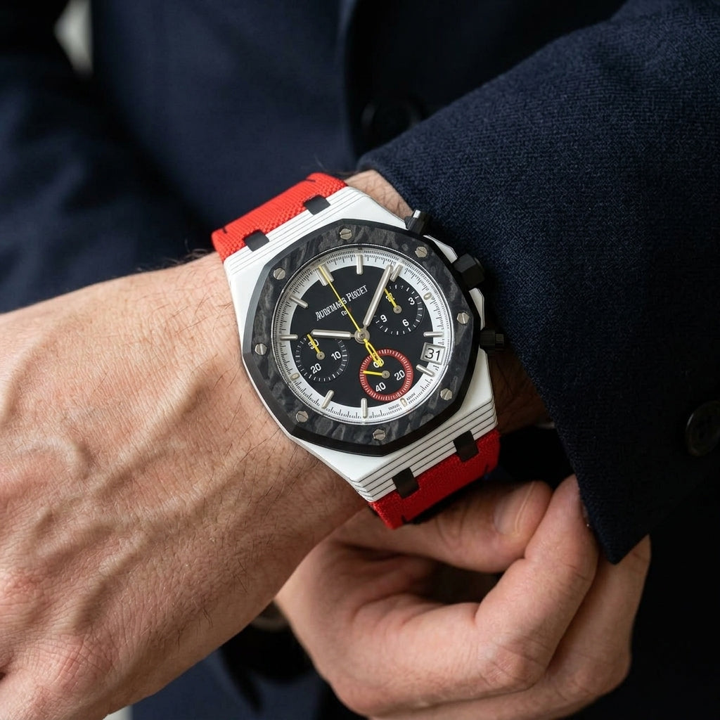 White octagonal chronograph with a black carbon bezel and a red canvas strap on the wrist as a shirt cuff is fastened