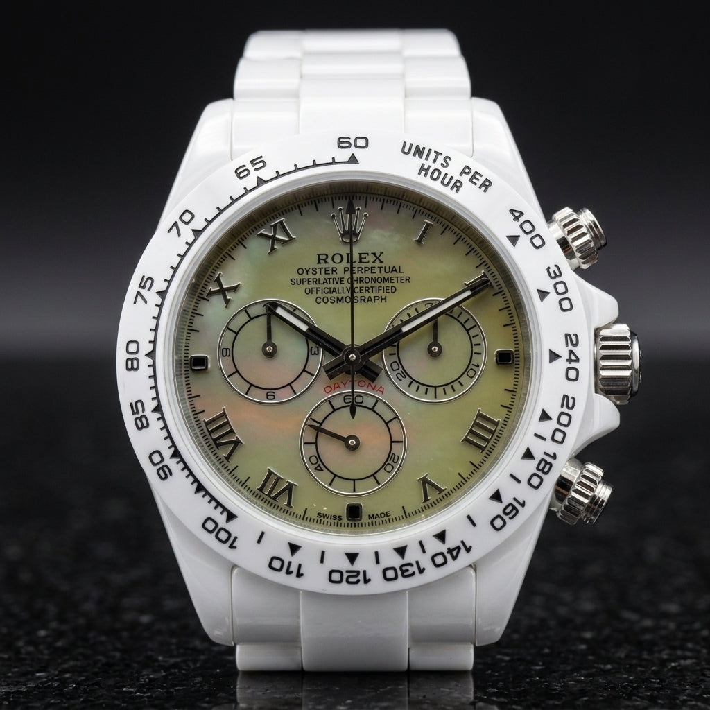 White ceramic chronograph with a green mother-of-pearl dial on the wrist below a dark suit cuff