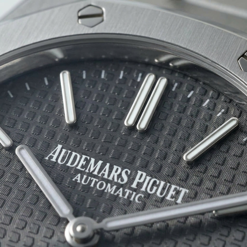 Macro of the slate tapisserie dial, its applied batons and the date window at three