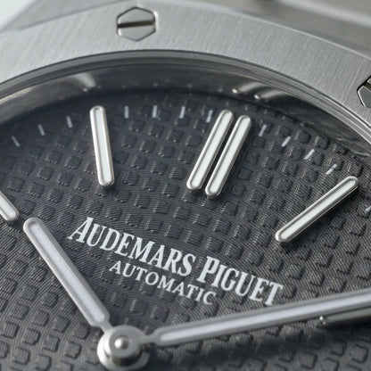 Macro of the slate tapisserie dial, its applied batons and the date window at three