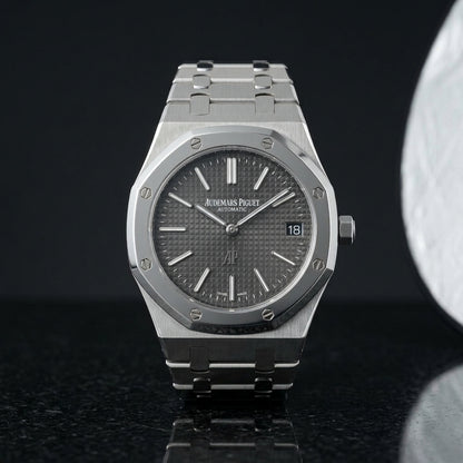Extra-thin steel octagonal sports watch on its integrated bracelet, worn under a shirt cuff