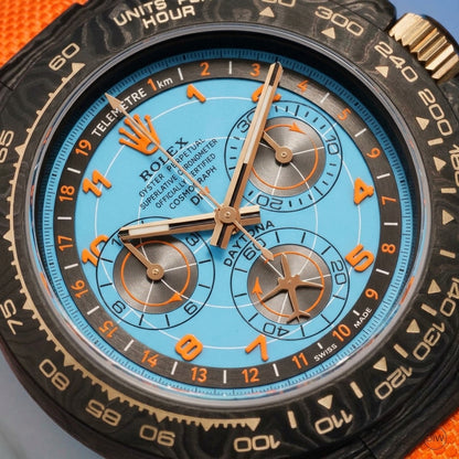 Macro of the ice-blue dial showing the orange Arabic numerals and the inner TELEMETRE scale
